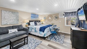 Une chambre à coucher avec un lit, un canapé, une petite table et une chaise.