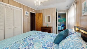 Quarto com cama, penteoude e espelho.