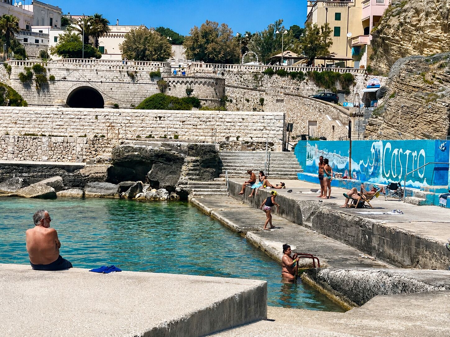 A stone bridge, a swimming pool, and a mural with the word 'CASTRO'.