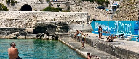 A stone bridge, a swimming pool, and a mural with the word 'CASTRO'.
