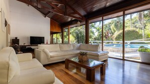 Una sala de estar amplia con un sofá grande, una mesa de centro y una televisión.