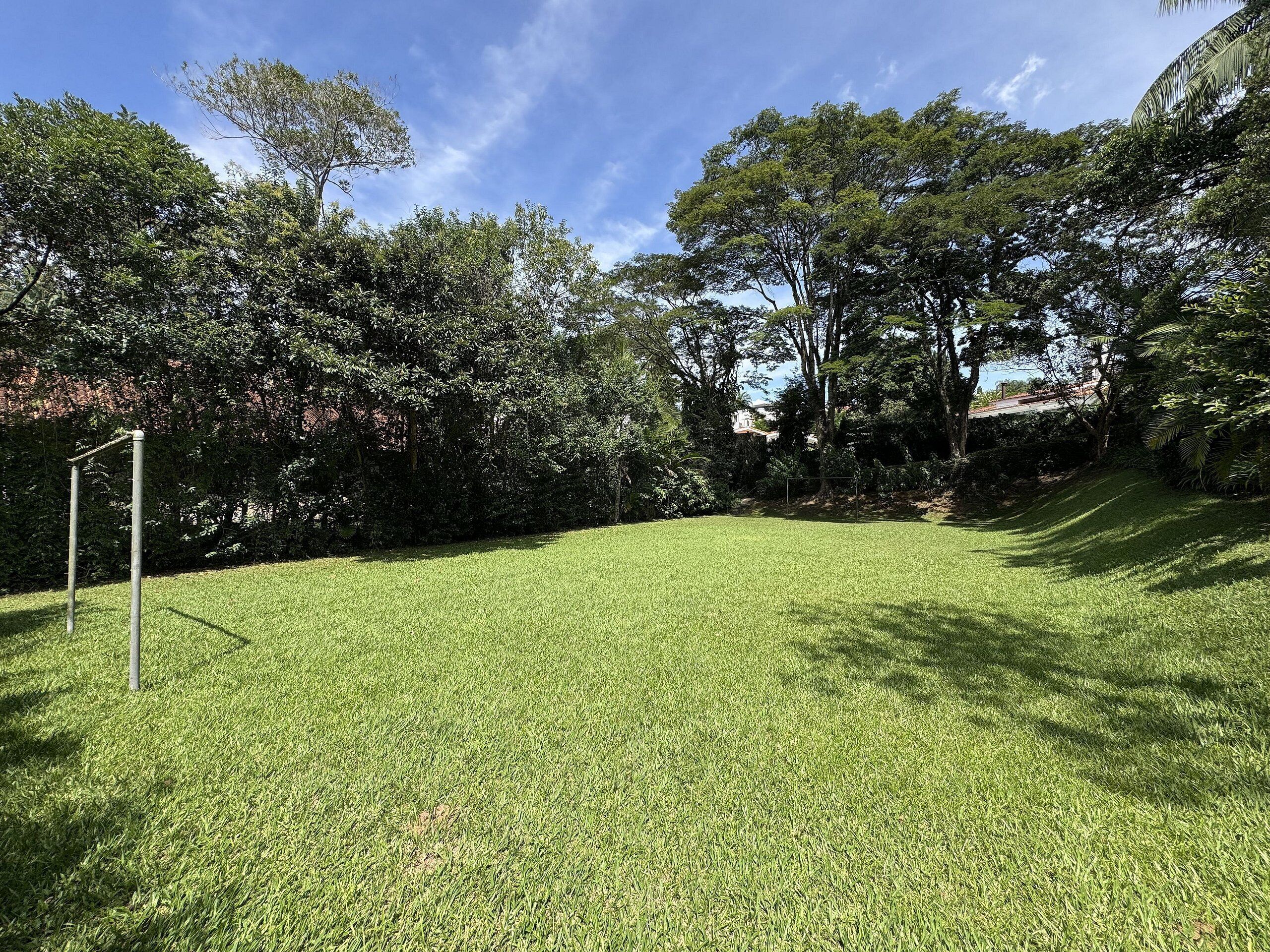 Un área verde bien cuidada con árboles y un cielo despejado.