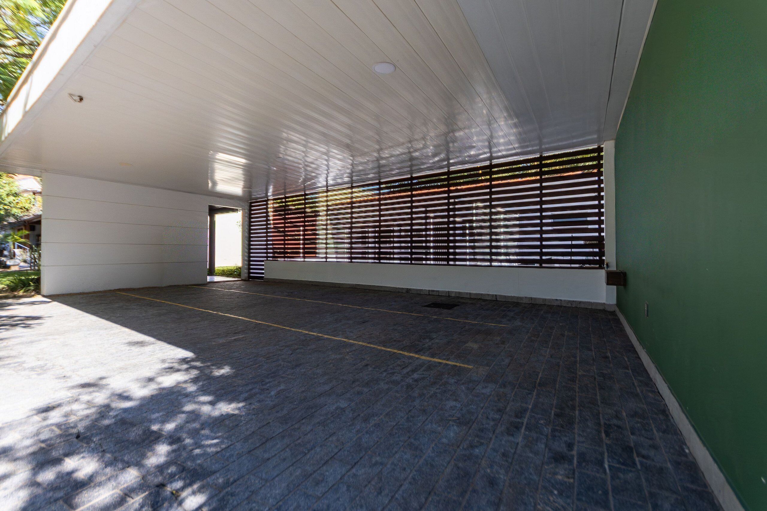 An indoor space with a tiled floor, a white ceiling, and a green wall.