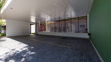 An indoor space with a tiled floor, a white ceiling, and a green wall.