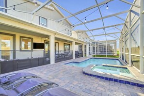 A covered outdoor swimming pool with lounge chairs, a hot tub, and a patio area with a pergola. - Magic awaits! 9BR resort home w Pool, Nr Disney (Kissimmee)