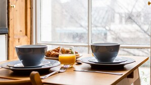 A breakfast table with bowls, a glass of orange juice, and croissants. - Chic 1 bed apartment Near British Museum (London)