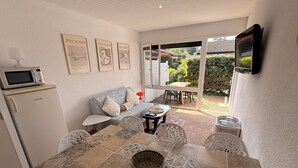 A dining area with a table, chairs, and a TV mounted on the wall.
