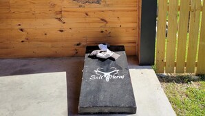A wooden wall with a hammock and a wooden fence. - Capn's Corner--1 BR, 1 Bath, Garage, Close to Beach, Dogs OK! (Port Aransas)