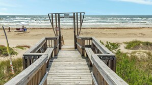 A wooden boardwalk leading to a beach with a sign indicating private property. - Direct Beach Access Classic Surfside Home (Surfside Beach)