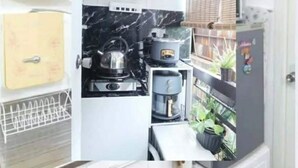 Une cuisine compacte équipée d’une machine à café, d’une bouilloire et d’un petit réfrigérateur.