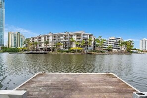 A waterfront hotel with multiple floors, balconies, and a dock. - Quiet River 1BR Hideaway (Surfers Paradise)