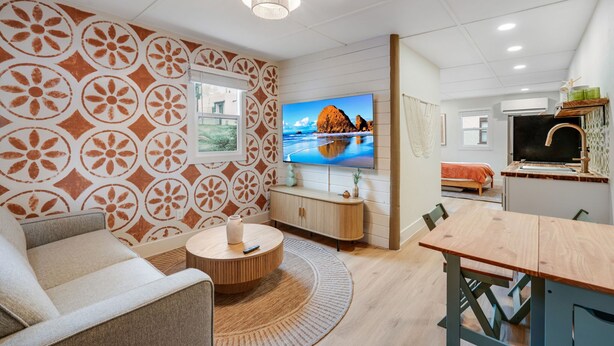 En moderne stue med fjernsyn, sofa og spisebord.