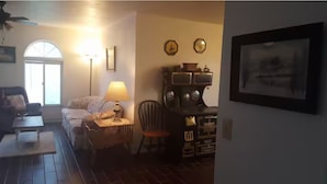 A living room with a sofa, a lamp, a chair, a coffee table, and a fireplace.