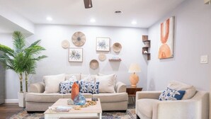 A living room with a sofa, armchair, coffee table, and decorative items on the walls. - Wonderful 2-bedroom townhome close to beach +Pool (Myrtle Beach)