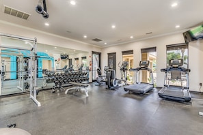 Ein Fitnessstudio mit Laufbändern, Crosstrainern und Gewichten.