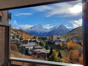 Eine Bergstadt mit Wohnhäusern und Blick auf schneebedeckte Berge.