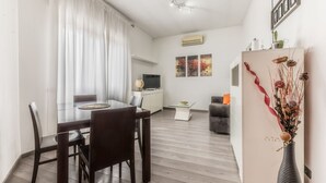 A modern living space with a dining area, kitchen, and seating area. - La casa di Faffo [Trionfale] (Rome)
