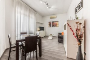 Un soggiorno moderno con zona pranzo, cucina e angolo relax.