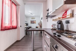 Una cucina moderna con piano cottura a gas, mobili in legno e un'area pranzo con tavolo e sedie.