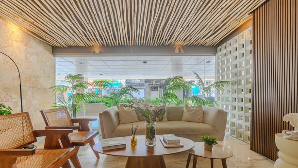A modern lobby with a sofa, chairs, a coffee table, and a decorative vase. - Majestuoso Apartamento 2 habitaciones  (Boca Chica)
