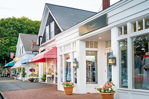 Uma fileira de edifícios brancos com lojas, incluindo uma placa visível para 'The Chatham Inn'.