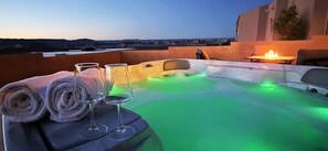 A hot tub with green lighting, a fire pit, and towels and glasses on a table. - Cliff Views, Game Room, Boat Parking (Page)