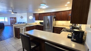 Une cuisine moderne avec des meubles en bois foncé, des appareils électroménagers en acier inoxydable et un îlot central.
