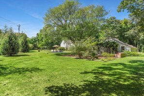 Il s’agit d’une propriété résidentielle dotée d’une pelouse bien entretenue, d’un petit espace patio et d’une maison entourée d’arbres.