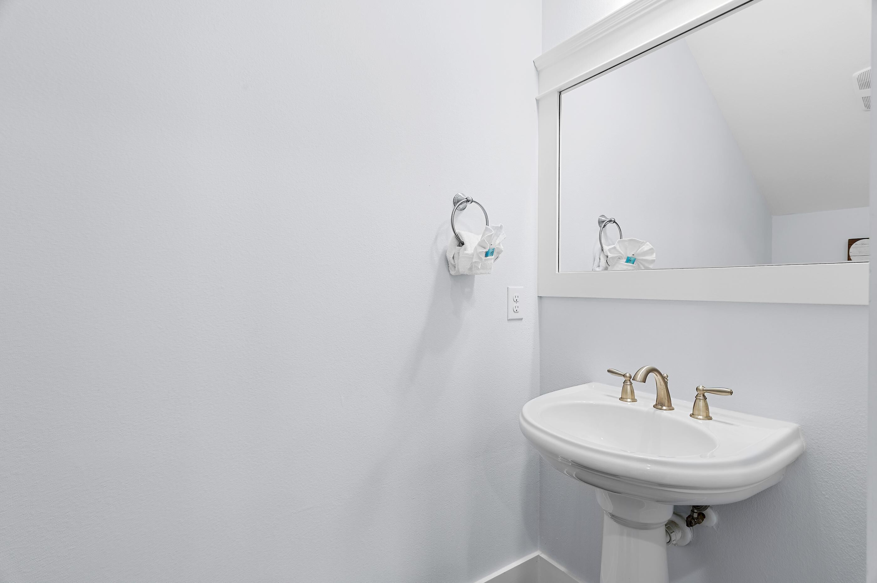 A white bathroom with a sink and a mirror.