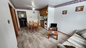 A compact living space with a dining area, kitchenette, and a sofa. - Crocker Cabins Unit 1 offers a self‑contained efficiency unit in Gros Morne. (Trout River)