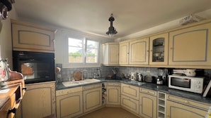 A kitchen with a sink, stove, microwave, and cabinets. - Family house at the foot of the dune 3 min between beach and market🤩🚲⛱️ (La Couarde-sur-Mer)