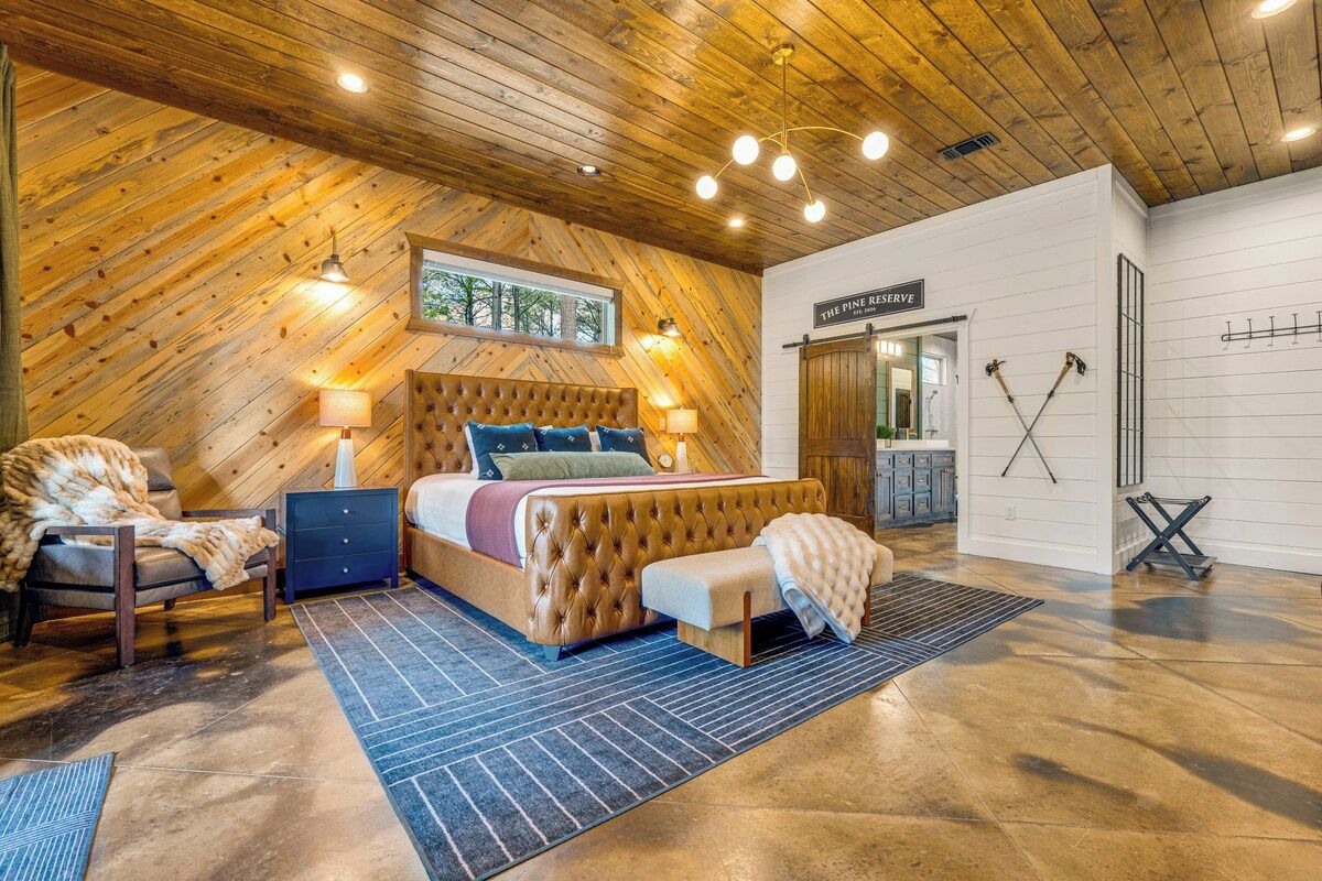 Une chambre à coucher avec un grand lit, un plafond en bois et une enseigne indiquant « The Pine Reserve ».