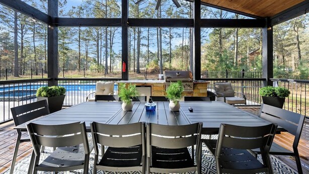 A covered outdoor patio with a pool, seating, and an outdoor kitchen. - Luxury Resort | Golf Sim, Pool, Gym, Sauna, 30 ppl (Broken Bow)