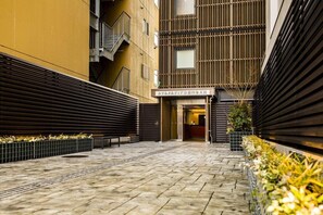 En hotelgang med et moderne design, med flisegulv, trappe og et skilt med hotellets navn.