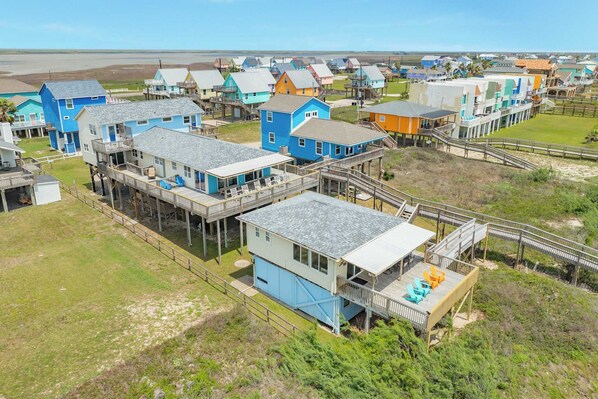 A coastal area with multiple wooden houses elevated on stilts, connected by walkways.
