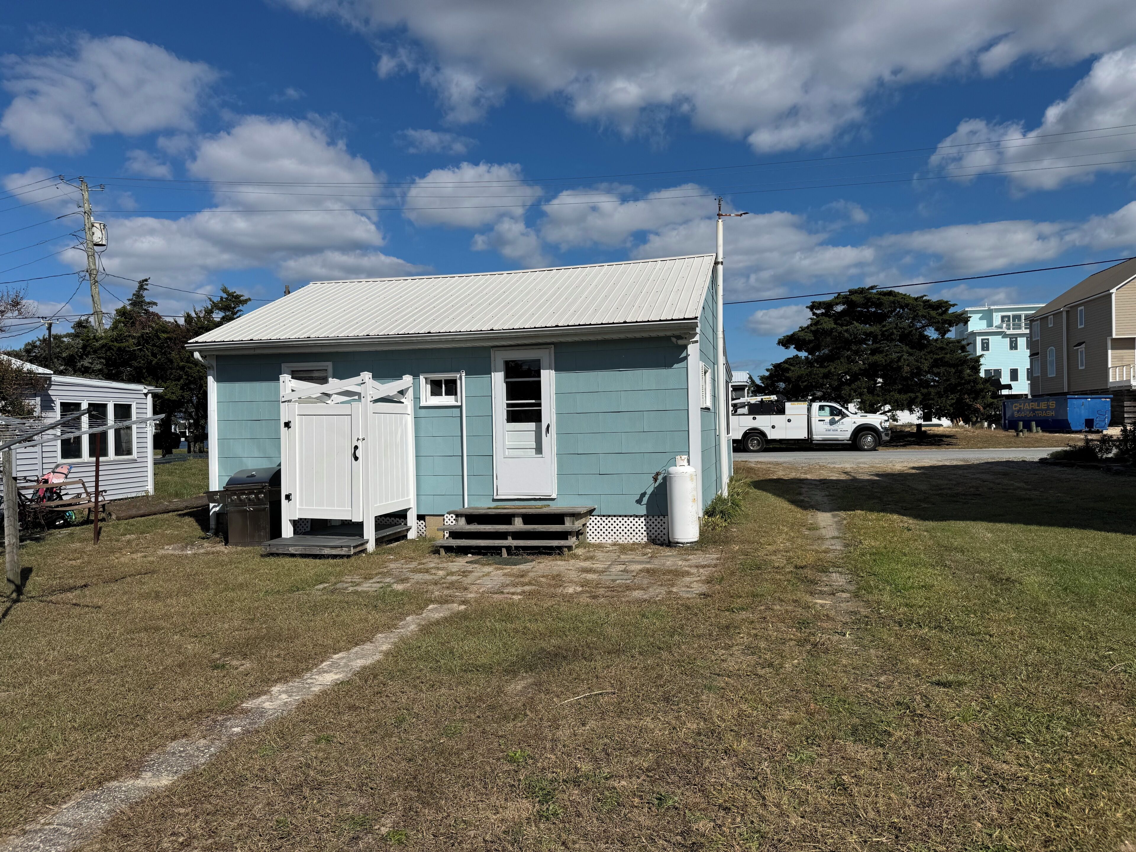 A small, single-story house with a white door and a small porch area.