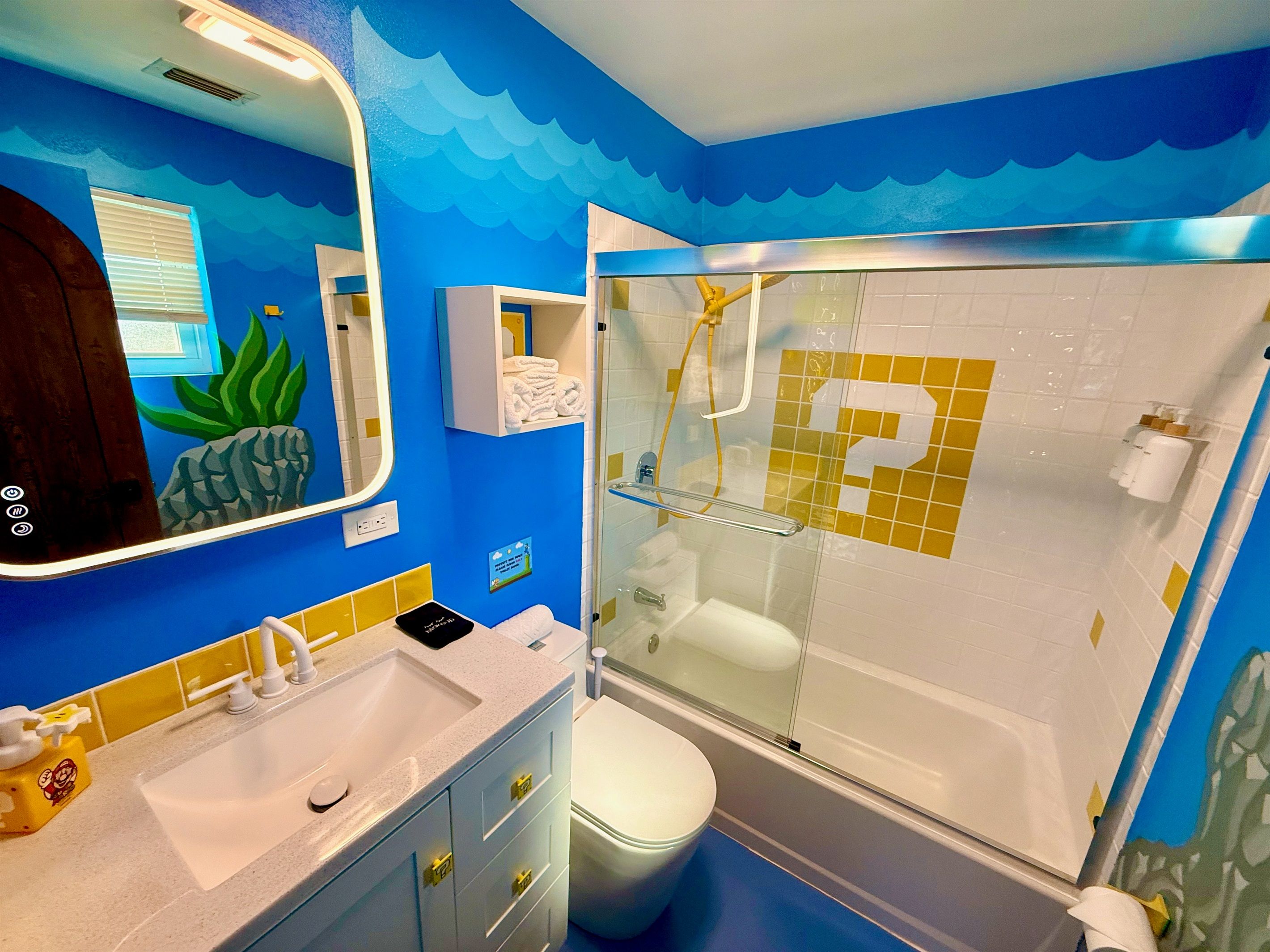 Een badkamer met een douchecabine, een wastafel met spiegel en een toilet.