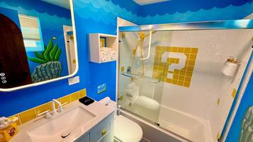 Een badkamer met een douchecabine, een wastafel met spiegel en een toilet.