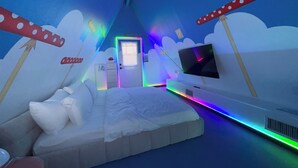 Een kamer met een bed, een televisie en een deur.