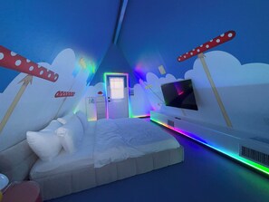 Une pièce avec un lit, une télévision et une porte.