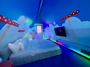 Een kamer met een bed, een televisie en een deur.