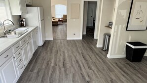 A kitchen with white cabinets, a stainless steel sink, and a refrigerator. - Spacious downtown oasis, free parking & laundry (Bellingham)