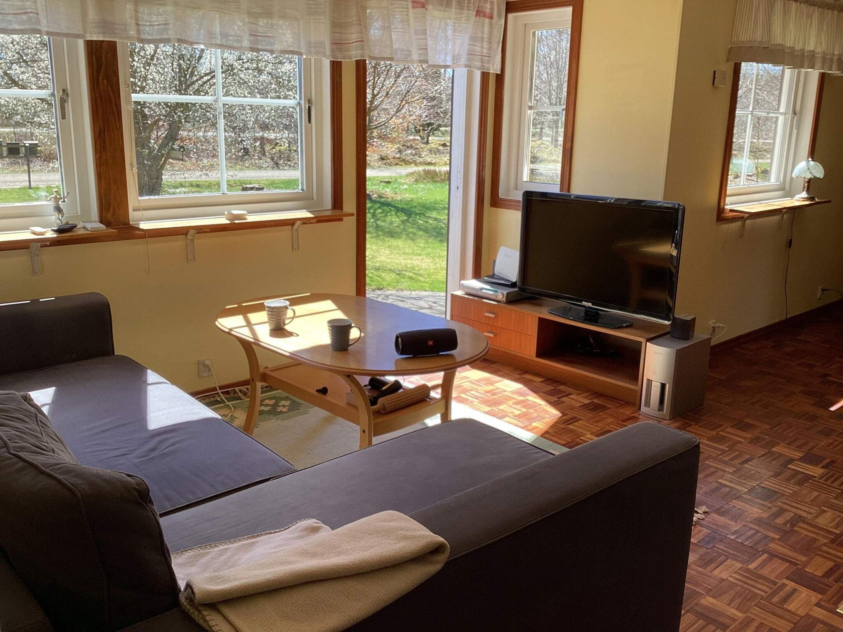Un salon comprenant un canapé, une table basse, un téléviseur à écran plat et une cheminée.