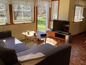 A living room with a sofa, a coffee table, a flat-screen TV, and a fireplace. - 6 Person Holiday Home in Ljungbyhed (Ljungbyhed)