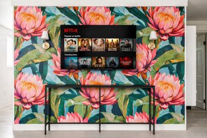 A wall with a Netflix display and a floral mural.