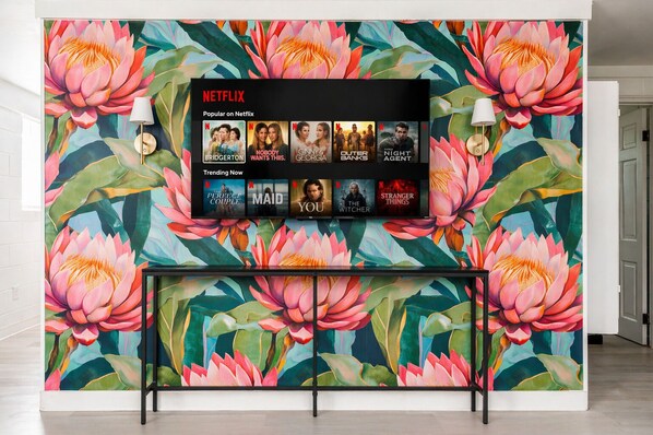 A wall with a Netflix display and a floral mural.