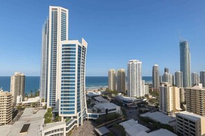 A cityscape with high-rise buildings, a clear sky, and a view of the ocean. - Ocean View Designer Apt SPA Wi-Fi (Surfers Paradise)