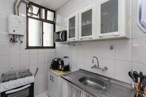 Eine Küche mit Gasherd, Mikrowelle und Backofen.