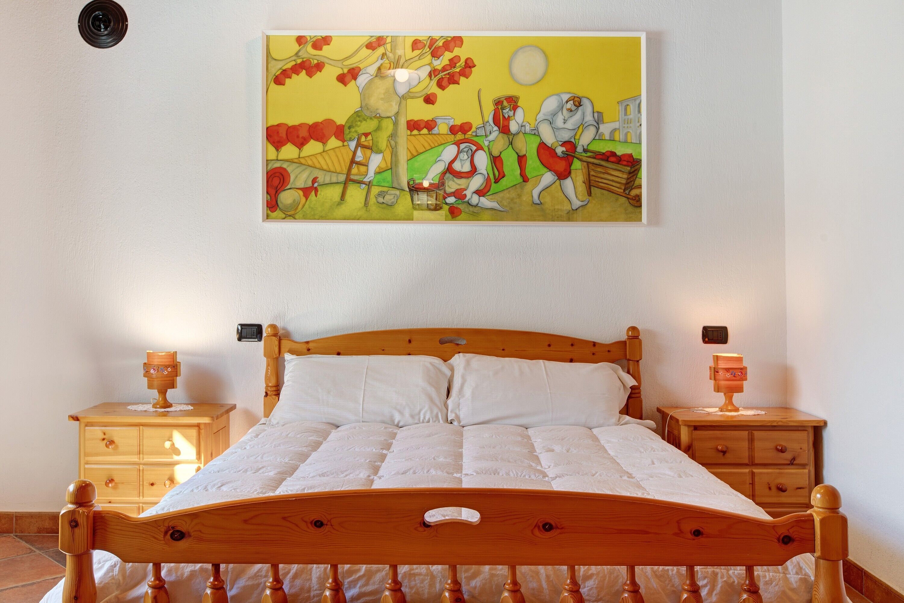 Ein Schlafzimmer mit einem hölzernen Bett, zwei Nachttischen und einem Gemälde an der Wand.
