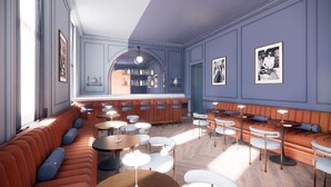 Een bar met krukken, een bargedeelte en een zithoek met banken en tafels.